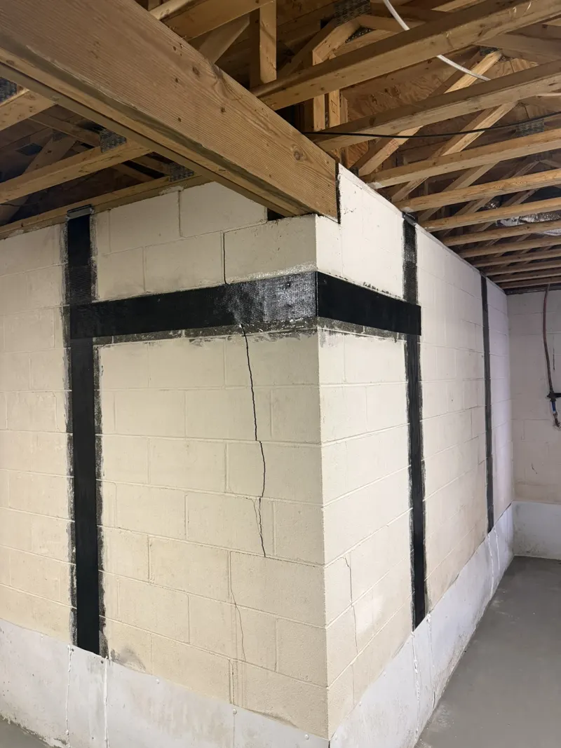 Carbon fiber straps on a block wall corner, with a stair-step crack visible between straps