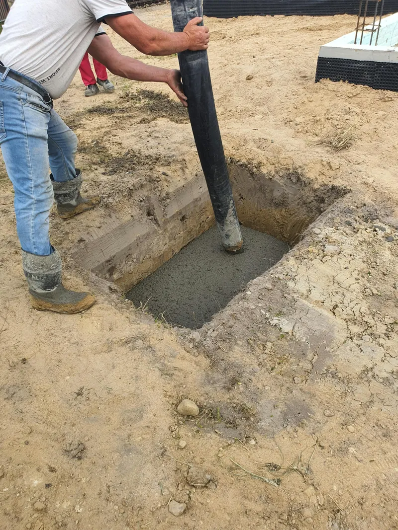 Concrete being placed into an excavated footing on a foundation job